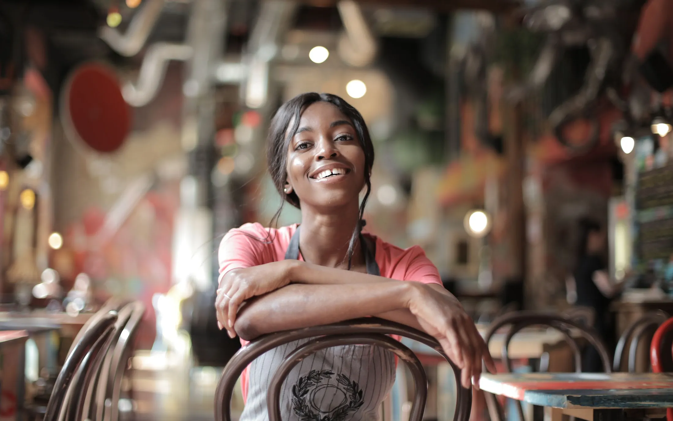 A woman leaning on a chair in the cafe she runs